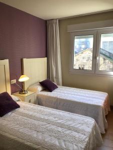ein Hotelzimmer mit 2 Betten und einem Fenster in der Unterkunft APARTAMENTO MOZART PORTONOVO Centro in Sanxenxo