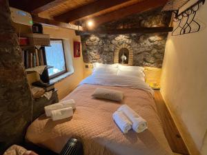 ein Schlafzimmer mit einem großen Bett in einer Steinmauer in der Unterkunft Agoriani Art Studio - Sweet little cottage in Lílaia
