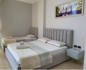 1 dormitorio con 2 camas y un cuadro en la pared en Eden Hotel, en Shëngjin