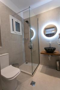 a bathroom with a shower and a toilet and a sink at Gaia Apartments I in Anthoúsa