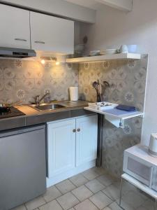 una cocina con armarios blancos y fregadero en Charming house close to the Plage des Huttes, en Chaucre