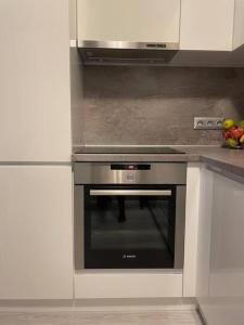 a stainless steel oven in a kitchen with white cabinets at ВАРНА СИТИ ПАРК С ПАРКОМЯСТО in Varna City