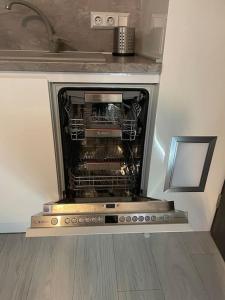 an oven with its door open in a kitchen at ВАРНА СИТИ ПАРК С ПАРКОМЯСТО in Varna City
