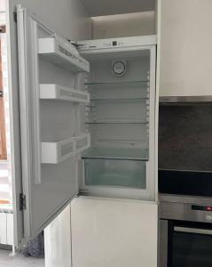 un réfrigérateur blanc vide avec sa porte ouverte dans l'établissement ВАРНА СИТИ ПАРК С ПАРКОМЯСТО, à Varna