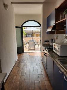 eine Küche mit einer offenen Tür zu einer Terrasse in der Unterkunft Domus Mariposa in Tortolì