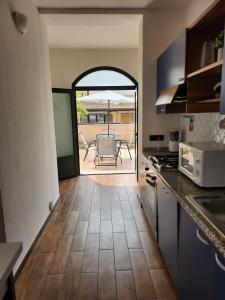 a kitchen with an open door to a patio at Domus Mariposa in Tortolì