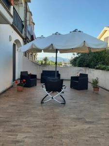 stół i krzesła pod parasolem na patio w obiekcie Domus Mariposa w mieście Tortolì