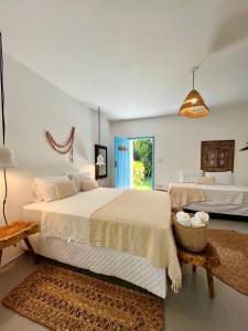 a large bedroom with two beds and a window at Pousada Caraíva in Caraíva