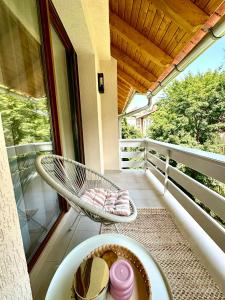 Un balcón con una silla, una mesa y una ventana en The Loft, en Sovata