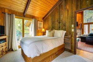 een slaapkamer met een bed in een kamer met houten wanden bij Jamaica Vacation Home with Deck 8 Mi to Skiing! in Jamaica