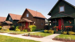 a row of houses with red and green at Amber Domki Letniskowe in Lubiatowo