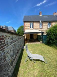 a chair sitting in the grass in front of a house at Neuville secrete in Dieppe