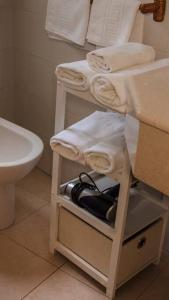 a bathroom with a shelf with towels and a sink at Apartamento Fernando Colón en Casco Histórico in Córdoba