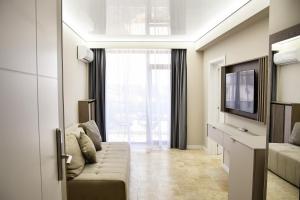 a living room with a couch and a television at AXO Boutique HOTEL by BUILDING STEFAN in Mamaia Sat/Năvodari