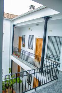 a white house with a balcony with a wooden door at Apartamento Fernando Colón en Casco Histórico in Córdoba