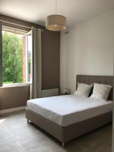 a bedroom with a bed and a large window at Neuville secrete in Dieppe