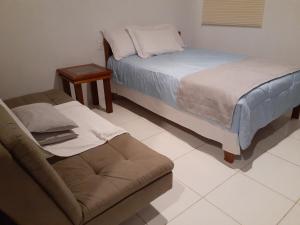 a room with two beds and a couch in it at Por do Sol in Florianópolis