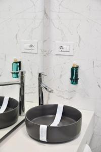 baño con lavabo negro y 2 grifos en AXO Boutique HOTEL by BUILDING STEFAN, en Năvodari