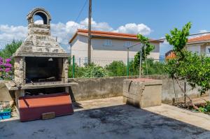 an outdoor grill in a yard with a building at Apartment Skoko in Slatine