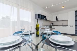 a dining room with a glass table and wine glasses at Apartment Skoko in Slatine