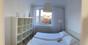 a small bedroom with a bed and a window at Apartamenty Studio W Ustce - 120 m2 - 200 m od plaży Mickiewicza 2, in Ustka