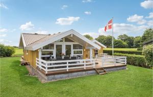 a small house with a porch and a flag at Gorgeous Home In Fars With Wifi in Farsø