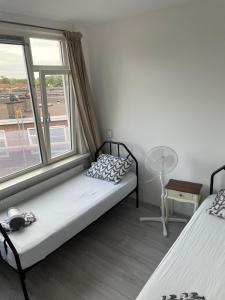 a bedroom with two beds and a window at Sunny and spacious apartment in Rotterdam