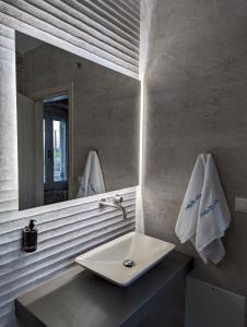 een badkamer met een wastafel en een spiegel bij Karystos Chora Suites in Karistos