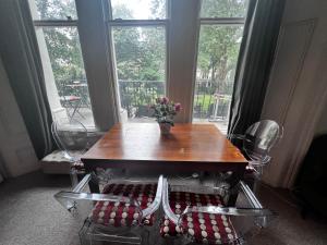 ロンドンにあるHyde Park Studio Has Private Balcony With Tranquil Garden Viewの窓のある部屋(テーブル、椅子付)