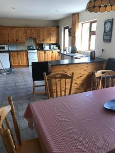 a kitchen with wooden cabinets and a table and chairs at Atlantic View in Castlegregory