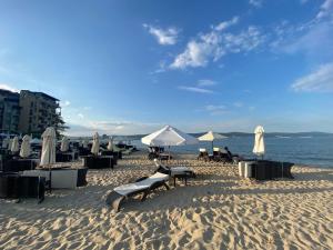een strand met stoelen en parasols op het zand bij SAPPHIRE 202 Studio Sunny Beach in Sunny Beach