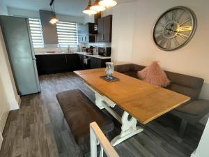 a living room with a table and a couch and a clock at Leerick Cottage in Conwy +19 photos