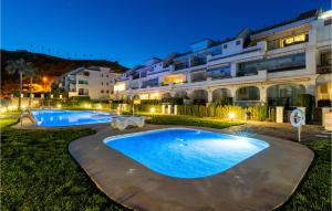 a swimming pool in front of a building at night at Lovely Apartment In Mlaga With Kitchenette in Málaga