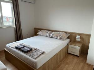 a small bedroom with a bed and a window at Royal Apartments in Neum