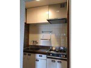 uma pequena cozinha com um lavatório e um fogão em Masaya Villa - Vacation STAY 23194v em Ito