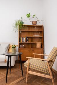 uma sala de estar com uma mesa e uma estante de livros em Apartament Vintage em Plock