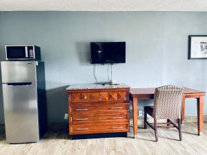 a kitchen with a table and a refrigerator and a desk with a television at Extended Stay SA in San Antonio