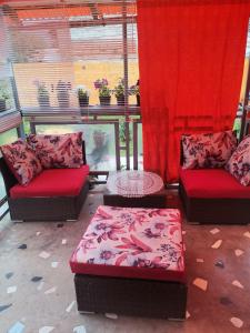 - un salon avec deux canapés et des rideaux rouges dans l'établissement T.I.M., à Bela Crkva
