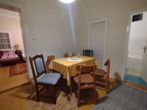 a dining room with a yellow table and chairs at T.I.M. in Bela Crkva