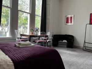 ロンドンにあるHyde Park Studio Has Private Balcony With Tranquil Garden Viewのベッドルーム1室(ベッド1台、テーブル、椅子付)