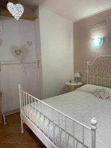 1 dormitorio con cama blanca y cuna en I Suoni di Valle Martina en Poderia