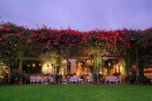 un jardín con mesas y flores y sillas rojas en Hermoso departamento en pueblo libre cerca al aeropuerto en Lima