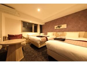 um quarto de hotel com duas camas e uma mesa em Hotel Torifito Kashiwanoha - Vacation STAY 75947v em Kashiwa