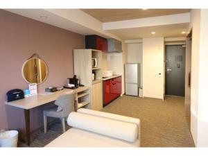 um quarto com uma secretária e uma cozinha com armários vermelhos em Hotel Torifito Kashiwanoha - Vacation STAY 75952v em Kashiwa