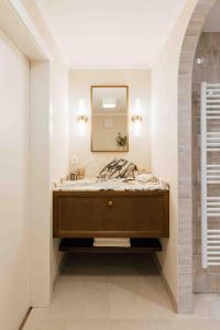 uma casa de banho com um lavatório e um espelho em Clemonte Hotel - Your Reception-less Boutique Hideaway em Salzburgo