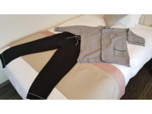 a bed with a shirt and trousers on it at Hotel Torifito Kashiwanoha - Vacation STAY 75948v in Kashiwa