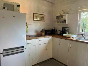 La cuisine est équipée d'un réfrigérateur blanc et d'un évier. dans l'établissement Zielony Zakątek, à Kretowiny