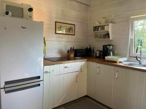 a kitchen with a white refrigerator and a sink at Zielony Zakątek in Kretowiny