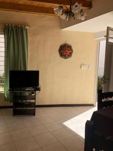 een woonkamer met een flatscreen-tv aan de muur bij Departamentos La Carmela in San Rafael