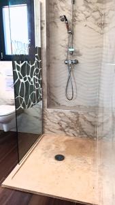 a shower in a bathroom with a glass door at Agréable chambre dans le maquis in Bonifacio
